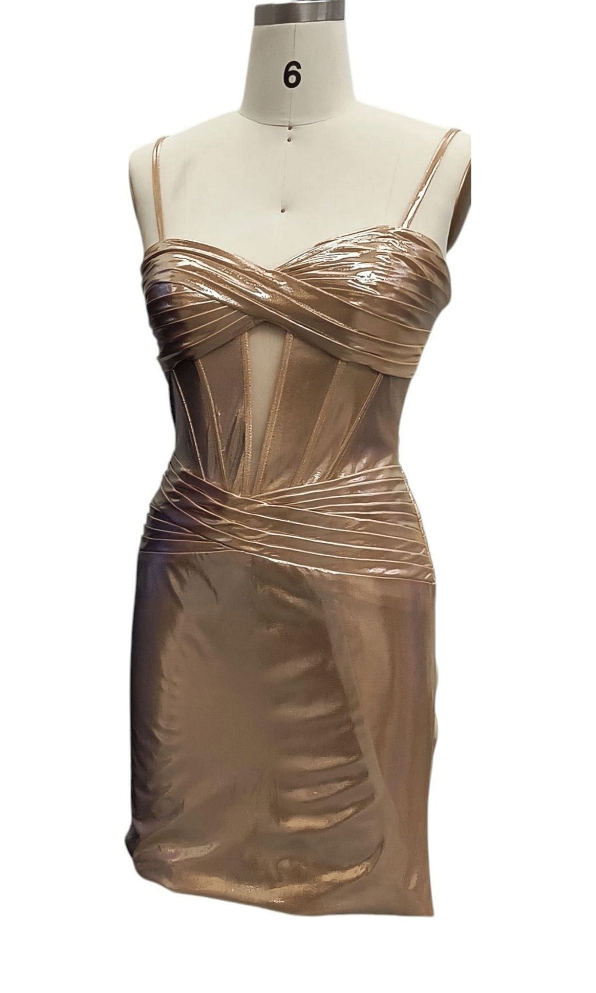The Cut-Out Short Metallic Hoco Dress: 12512, a nude mini dress with thin spaghetti straps, a corset-style bodice, and structured ruched details, is displayed on a dress form.